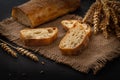 Italian traditional ciabatta bread with sliced Ã¢â¬â¹Ã¢â¬â¹pieces and ears of wheat lie on a jute napkin on a table Royalty Free Stock Photo